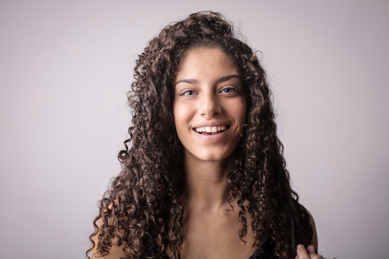 Portrait Photo of Smiling Woman with Brown Curly Hair