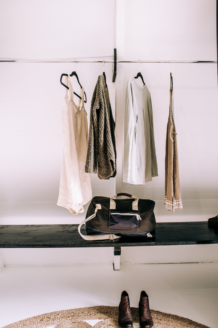 Clothes Hanging on a Rack and Boots Standing on the Floor 